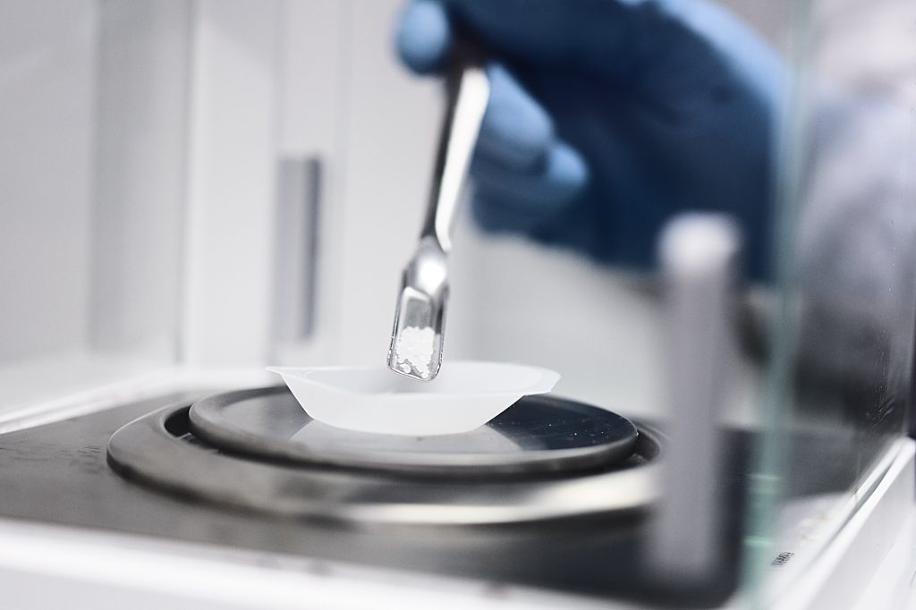 Wissenschaftliche Reportage im Labor - genaues Abwiegen wird ästhetisch in einer Laborumgebung gezeigt